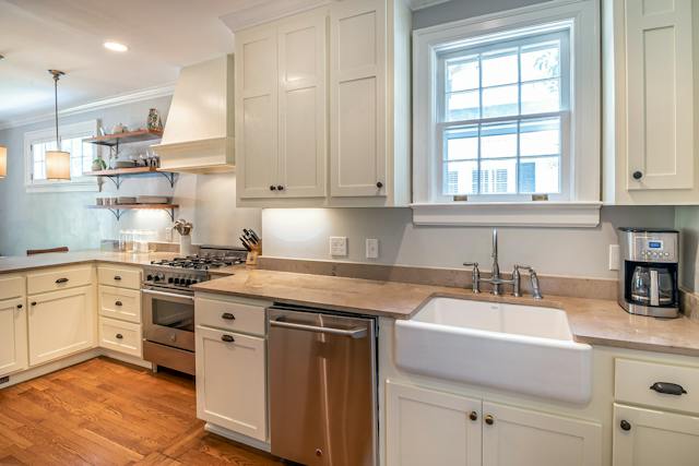 a%20kitchen%20with%20hard%20wood%20floors,%20white%20cabinets%20and%20stainless%20steel%20appliances